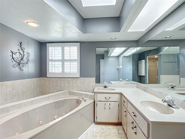 full bath featuring a skylight, a sink, a tub with jets, and double vanity