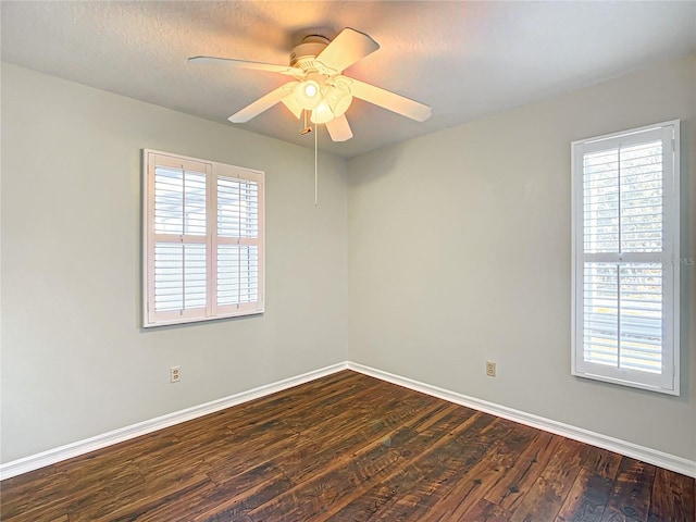 spare room with dark wood-style floors, a textured ceiling, baseboards, and a ceiling fan