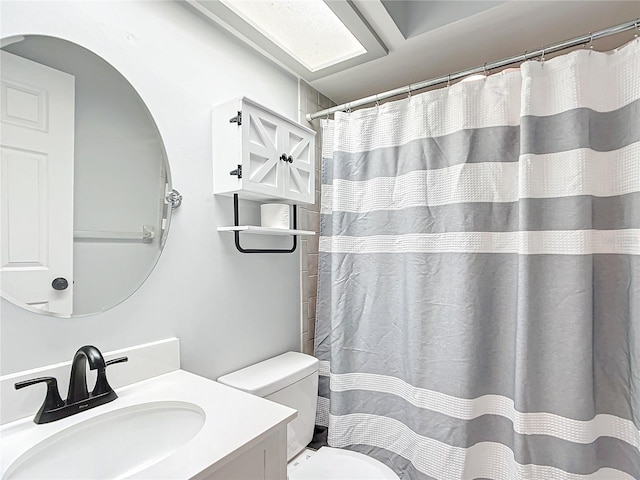 full bath with curtained shower, vanity, and toilet