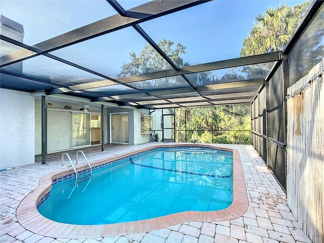 pool with glass enclosure and a patio