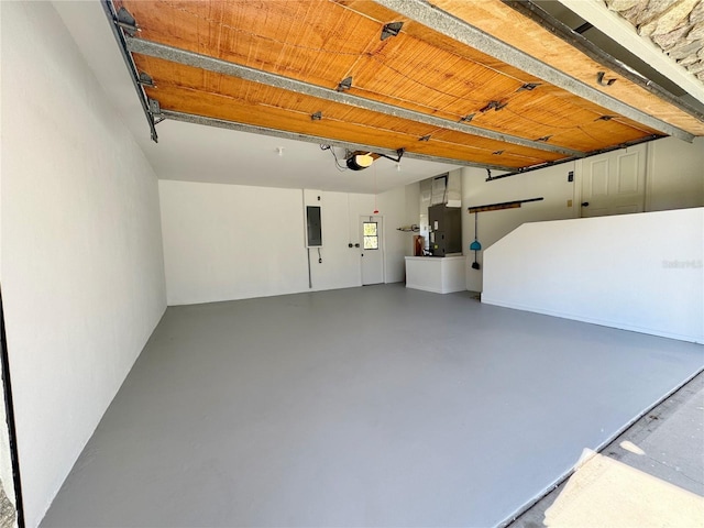 garage featuring heating unit, electric panel, and a garage door opener