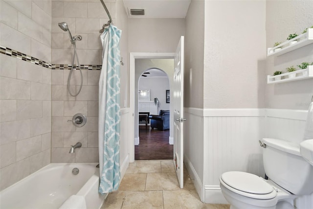 bathroom with shower / tub combo with curtain and toilet