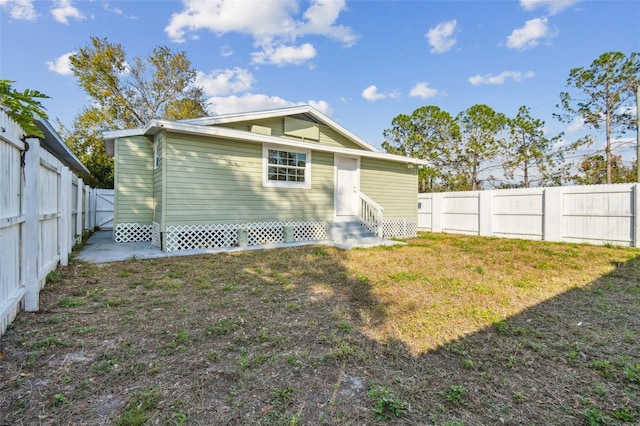 back of property featuring a lawn