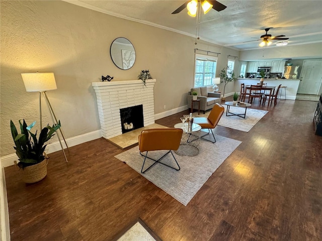 living room featuring a textured ceiling, ceiling fan, crown molding, a fireplace, and dark hardwood / wood-style floors