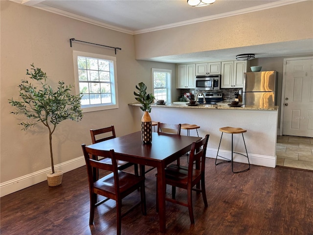 dining area featuring ornamental molding and dark hardwood / wood-style floors