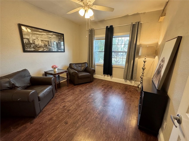 living area featuring ceiling fan and dark wood-type flooring