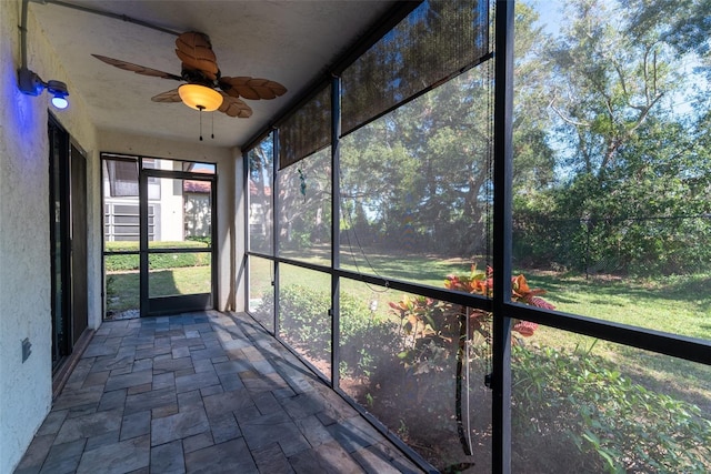 unfurnished sunroom with ceiling fan