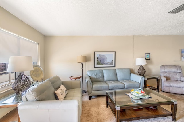 living room with light colored carpet, visible vents, and a textured ceiling