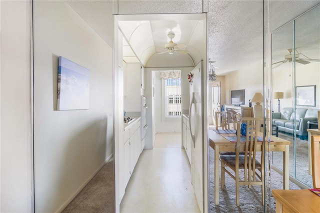 corridor with a textured ceiling and light floors