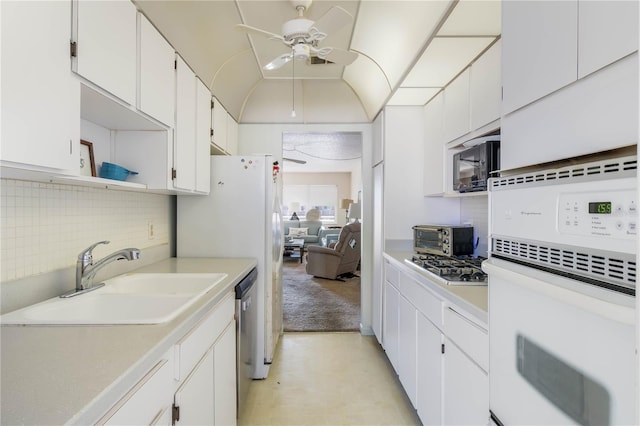 kitchen with light countertops, appliances with stainless steel finishes, white cabinets, a sink, and ceiling fan