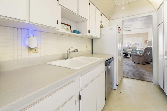 kitchen with light countertops, backsplash, white cabinets, a sink, and dishwasher