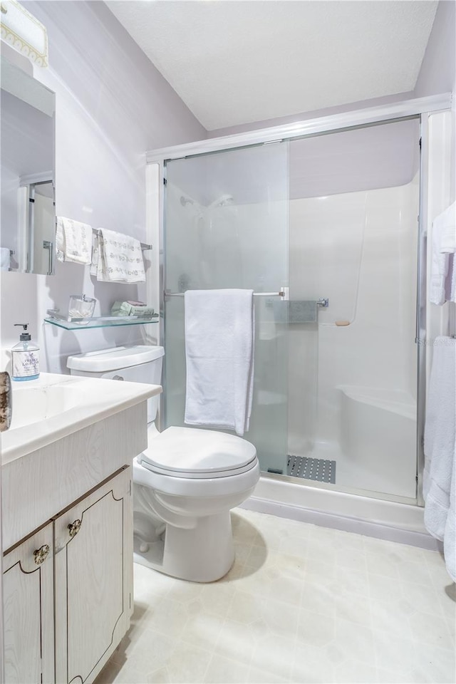 full bathroom with vanity, a shower stall, and toilet