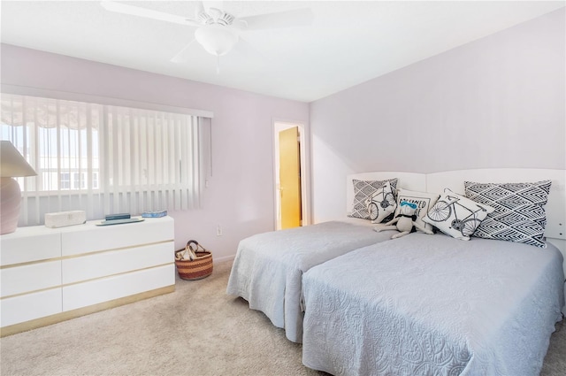 bedroom with a ceiling fan, light colored carpet, and baseboards