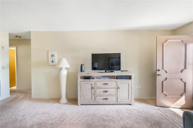 living room with a textured ceiling, baseboards, and light colored carpet