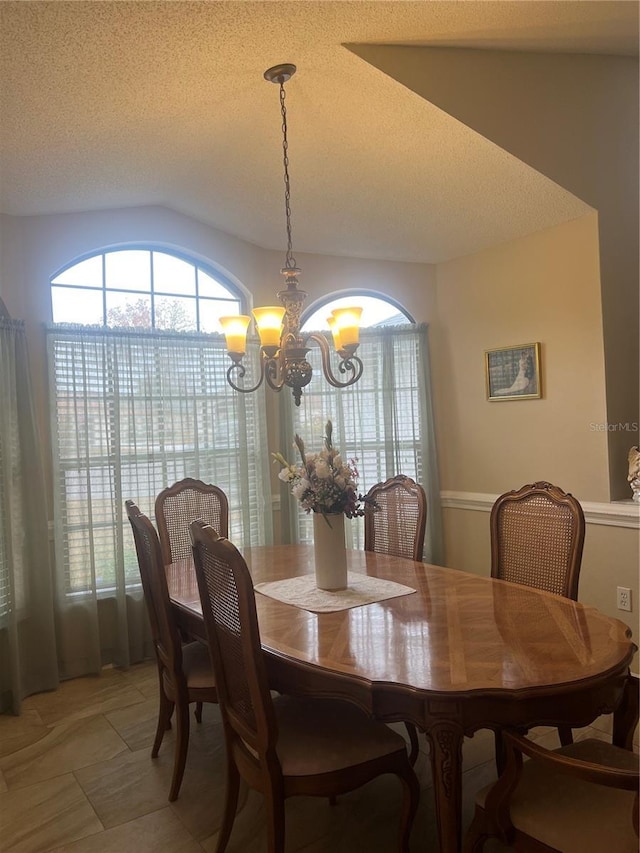 dining space with a chandelier and a textured ceiling