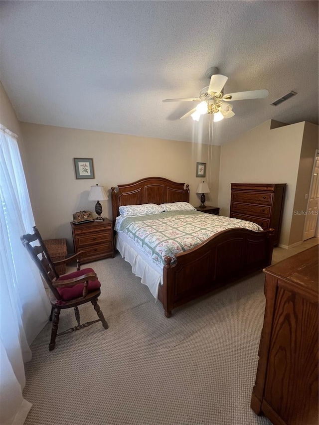 carpeted bedroom featuring ceiling fan, lofted ceiling, and a textured ceiling