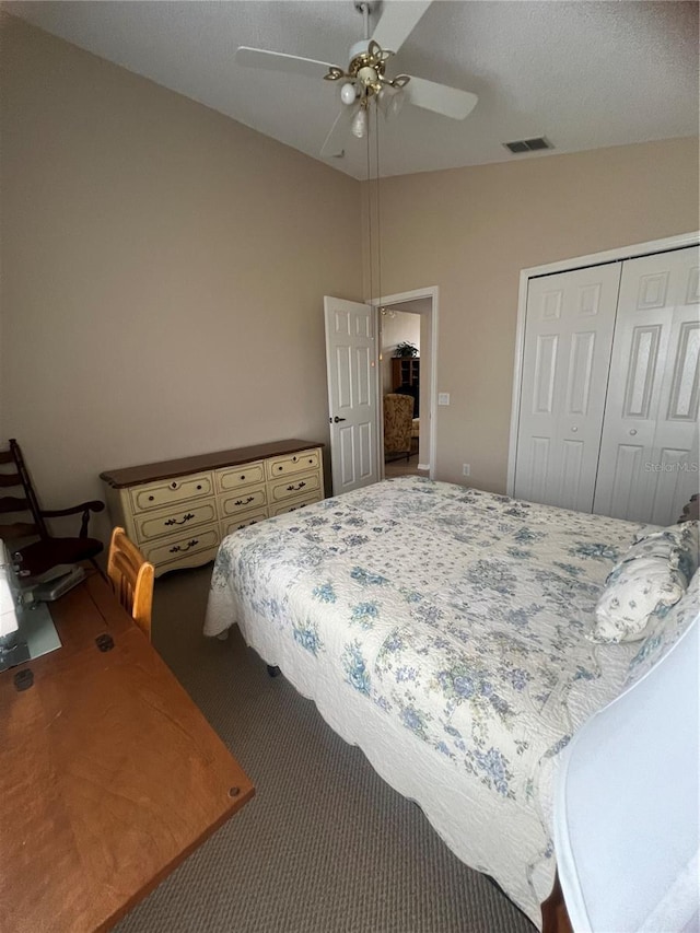 bedroom with vaulted ceiling, ceiling fan, carpet floors, and a closet