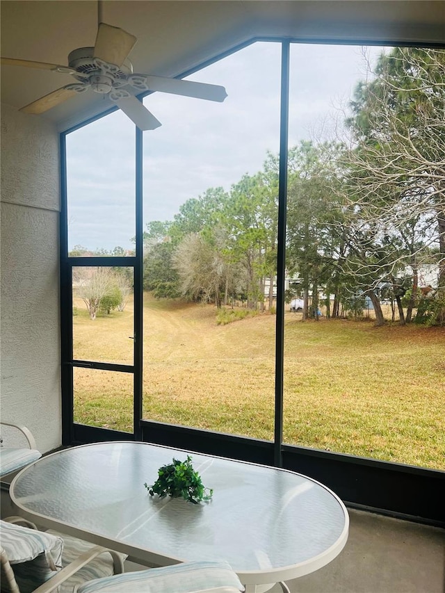 unfurnished sunroom featuring ceiling fan