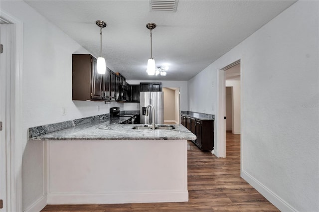 kitchen with sink, pendant lighting, dark brown cabinetry, and black electric range oven