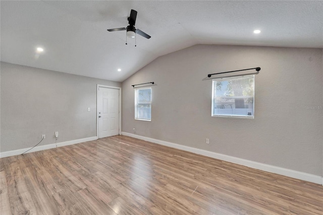 spare room with lofted ceiling, ceiling fan, and light hardwood / wood-style flooring