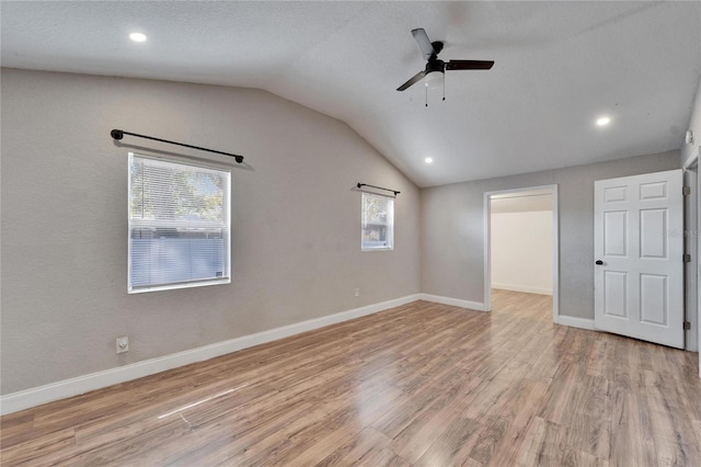 unfurnished room with ceiling fan, lofted ceiling, light hardwood / wood-style flooring, and a textured ceiling