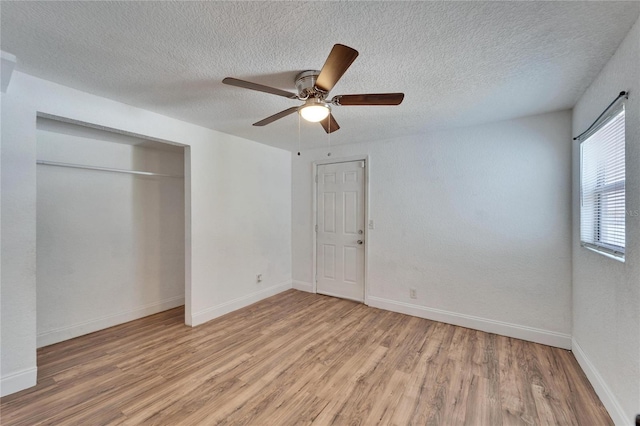 unfurnished bedroom featuring ceiling fan, a textured ceiling, light hardwood / wood-style floors, and a closet