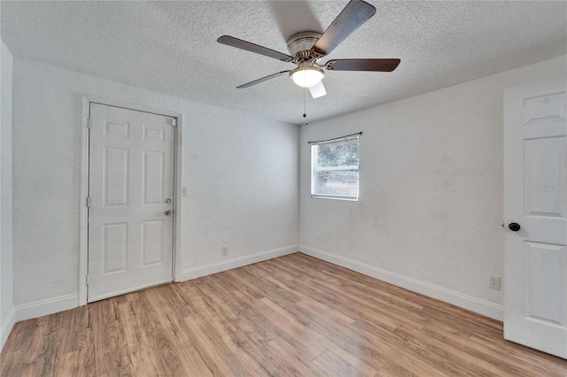 empty room with ceiling fan, a textured ceiling, and light wood-type flooring