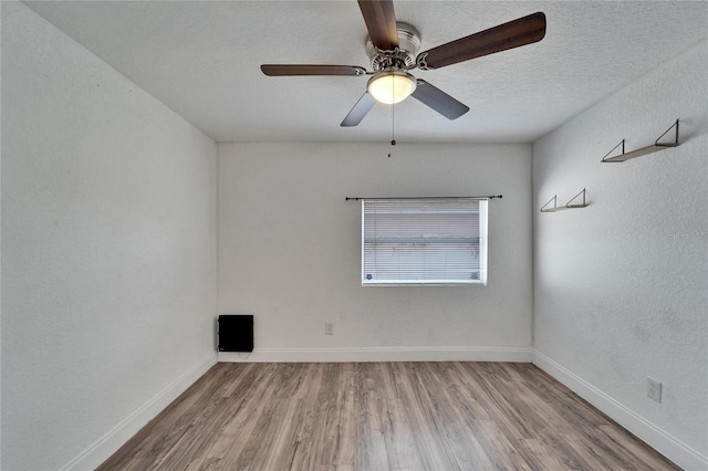 spare room featuring hardwood / wood-style flooring, ceiling fan, and a textured ceiling