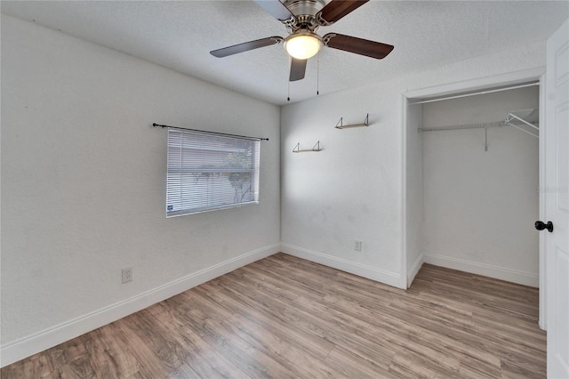 unfurnished bedroom with a textured ceiling, a closet, ceiling fan, and light wood-type flooring