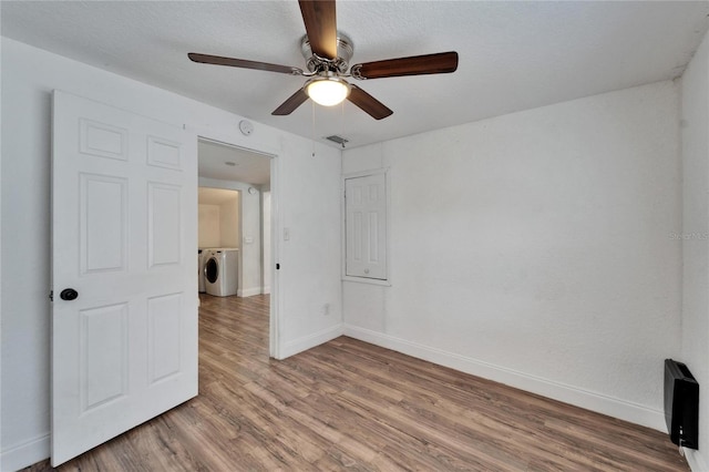 spare room with hardwood / wood-style flooring, ceiling fan, and washer / dryer