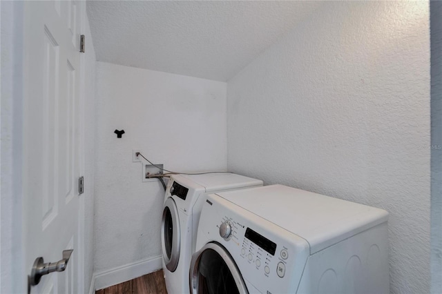 clothes washing area featuring separate washer and dryer, a textured ceiling, and dark hardwood / wood-style flooring