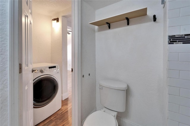 bathroom with wood-type flooring, toilet, and washer / dryer