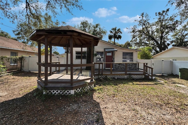 rear view of property featuring a wooden deck and a gazebo