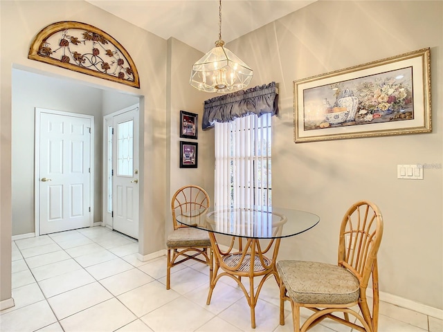 tiled dining room featuring a chandelier