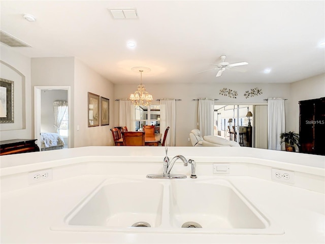 bathroom with sink, ceiling fan with notable chandelier, and a washtub