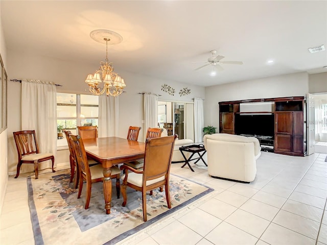 tiled dining room featuring ceiling fan with notable chandelier and a healthy amount of sunlight