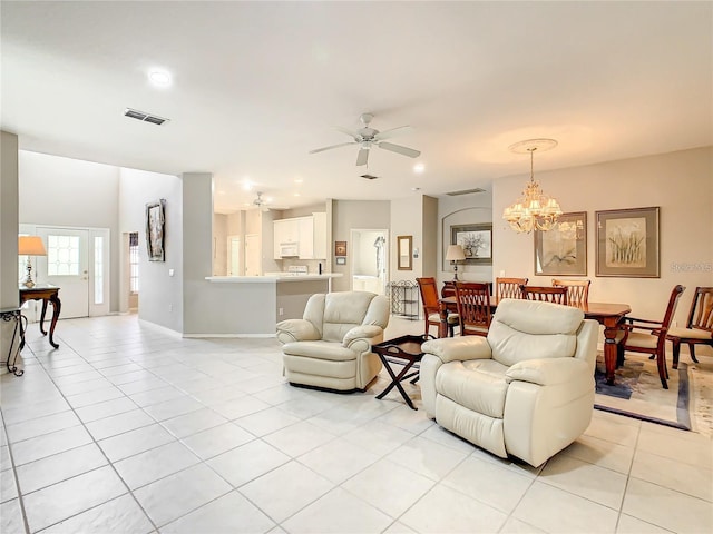 living room with light tile patterned flooring and ceiling fan with notable chandelier