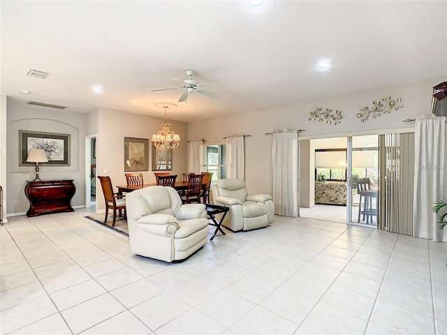 tiled living room with a healthy amount of sunlight and ceiling fan with notable chandelier