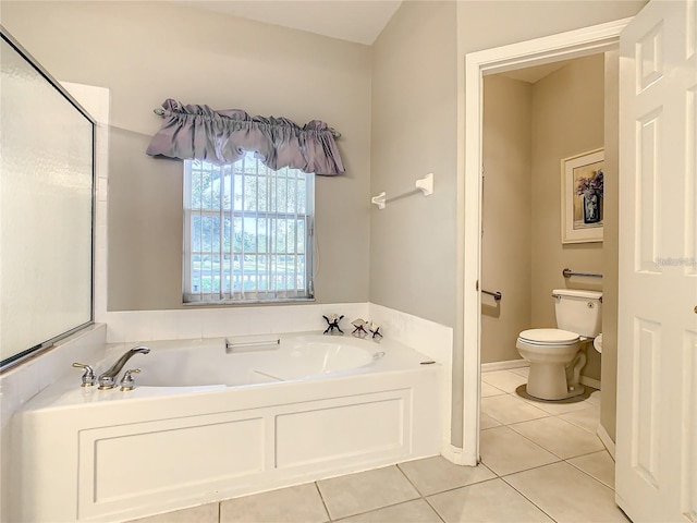 bathroom featuring tile patterned flooring, a bath, and toilet