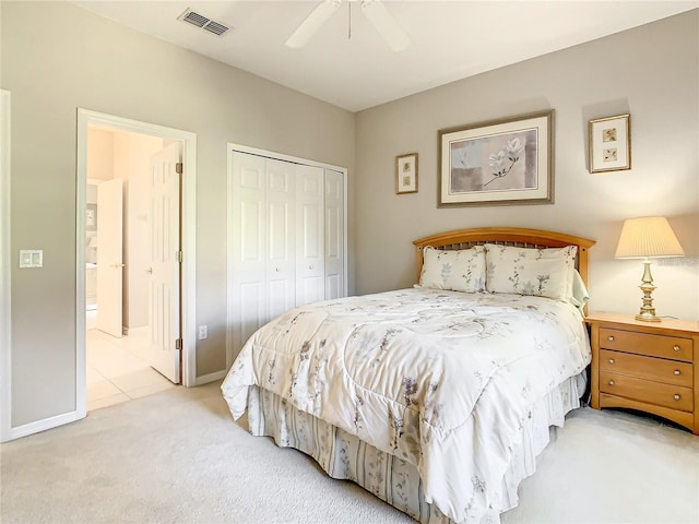 carpeted bedroom featuring connected bathroom, ceiling fan, and a closet