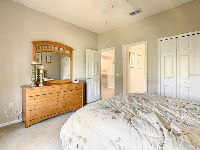 bedroom featuring light colored carpet, ceiling fan, and a closet