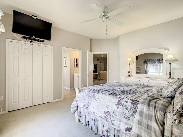 carpeted bedroom featuring ensuite bathroom, ceiling fan, and a closet