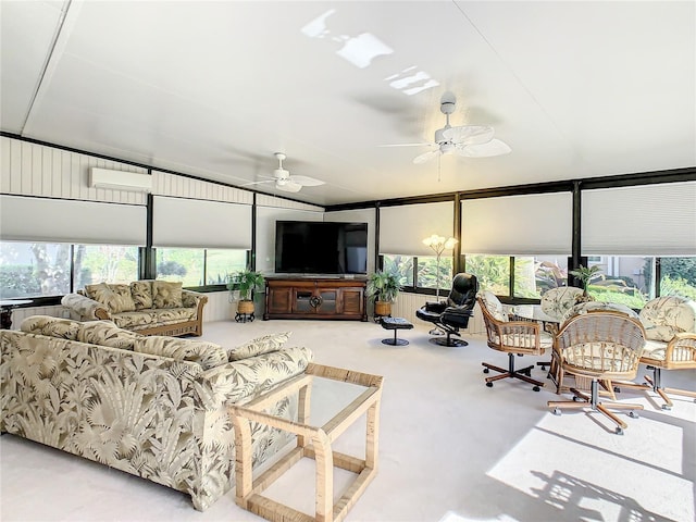 living room featuring ceiling fan, plenty of natural light, carpet flooring, and a wall unit AC