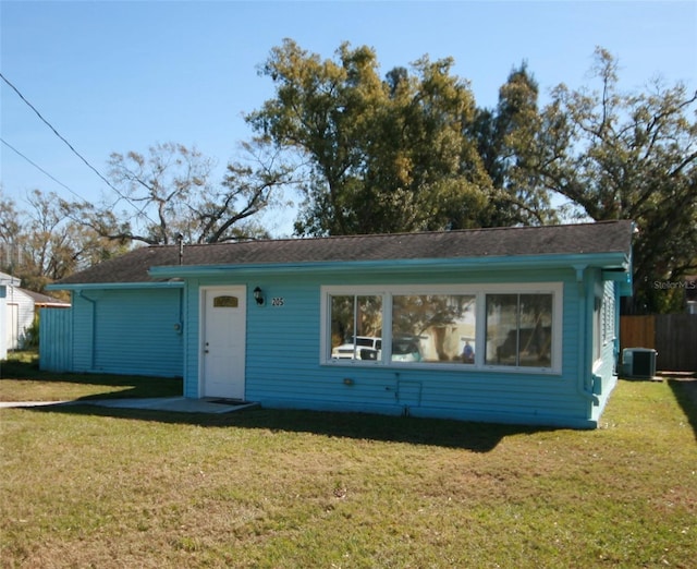 view of front of house with central AC unit and a front yard