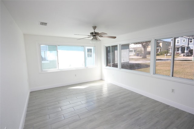 unfurnished sunroom with ceiling fan