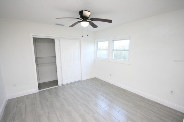 unfurnished bedroom featuring ceiling fan, a closet, and light wood-type flooring