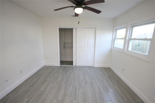 unfurnished bedroom with ceiling fan, a closet, and light hardwood / wood-style flooring