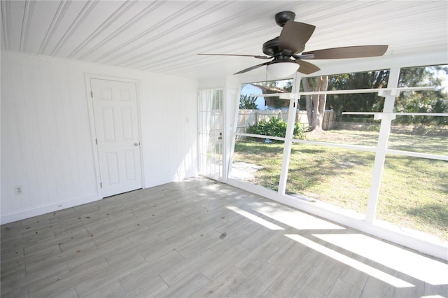 unfurnished sunroom featuring ceiling fan