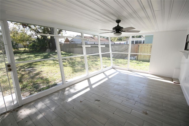 unfurnished sunroom featuring plenty of natural light and ceiling fan