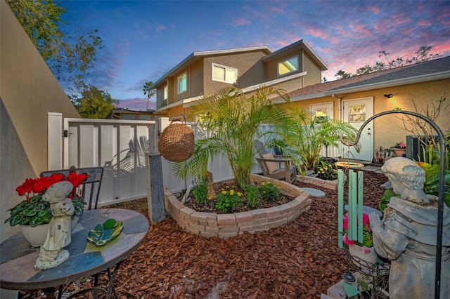 yard at dusk featuring a gate and fence